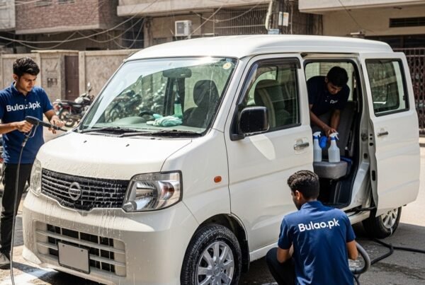 White Nissan Clipper compact van being professionally detailed by Bulao.pk technicians in navy blue t-shirts with 'Bulao.pk' on them. Technicians are cleaning the exterior, wheels, and interior in a Karachi street setting, showcasing a clean, polished, and hygienic van