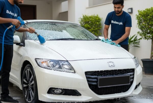 Bulao.pk technicians detailing a pearl white Honda CR-Z in Karachi, applying foam and wiping the hood for a sleek, showroom-like finish.